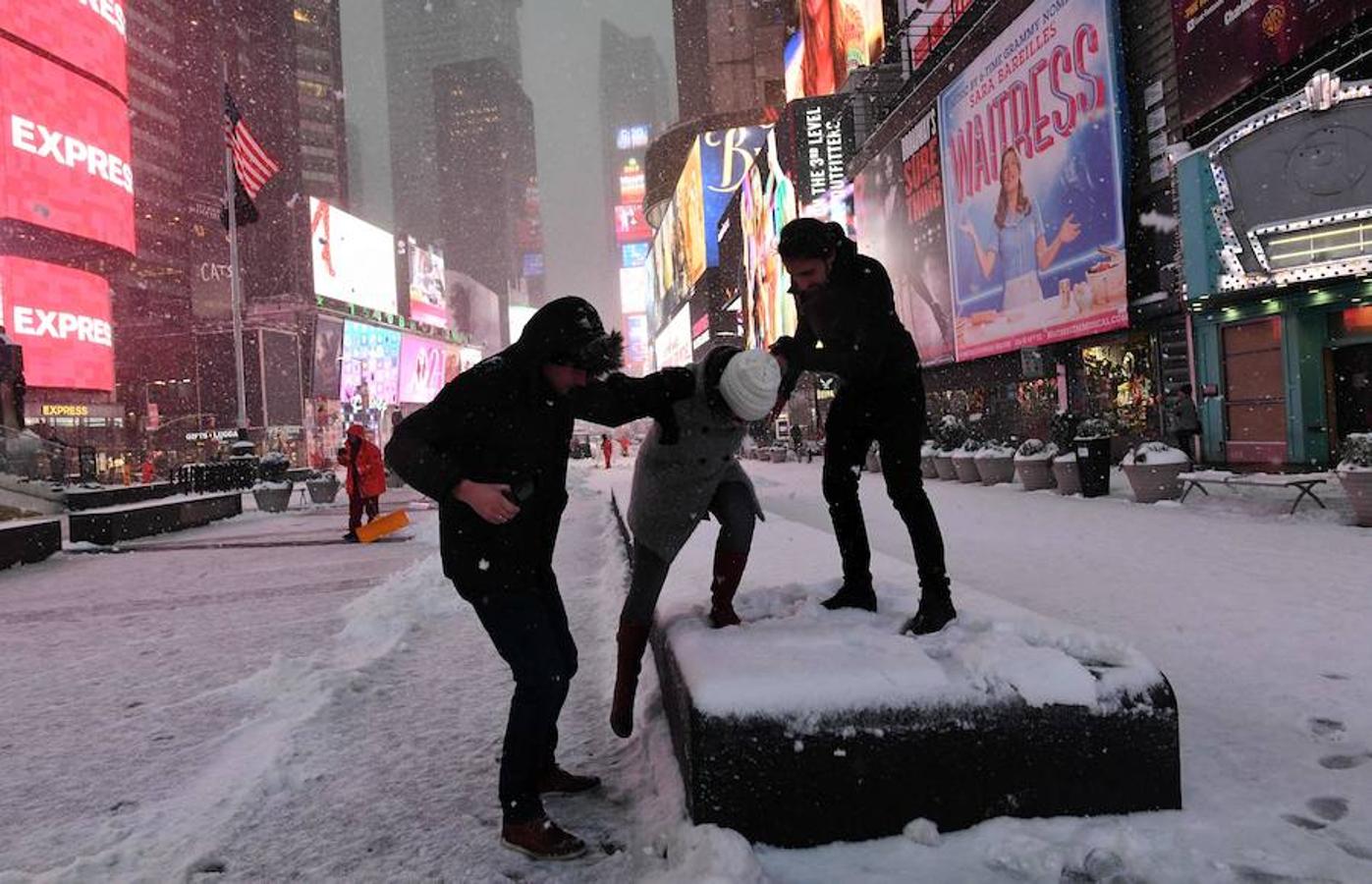 Un grupo de jóvenes juega con la nieve en Times Square. 