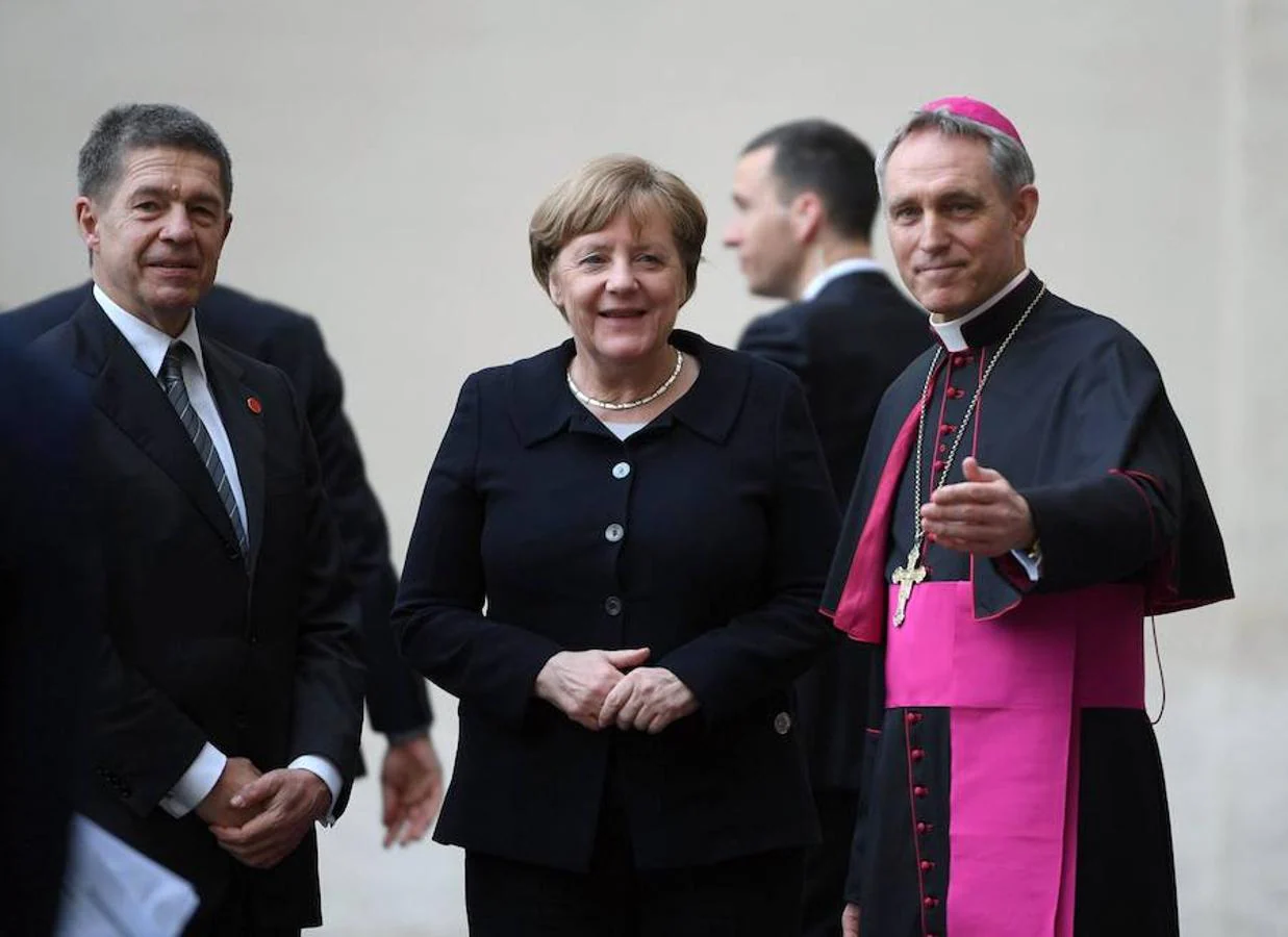 El arzobispo Georg Ganswein (d) recibe a la canciller alemana, Angela Merkel (c), y a su marido, Joachim Sauer (i), a su llegada a una reunión con el Papa Francisco con motivo del 60 aniversario del Tratado de Roma en su víspera en Ciudad del Vaticano