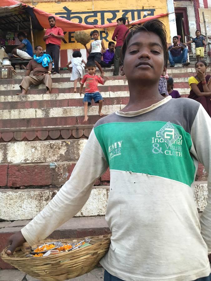Con solo 12 años, Raj vende flores para ofrendas a orillas del sagrado río Ganges.. 