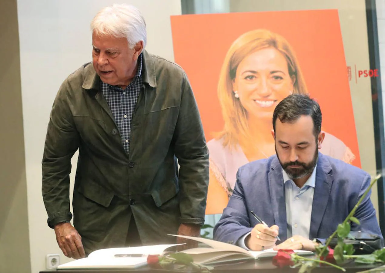 El expresidente del Gobierno, Felipe González (i), firma en el libro de condolencias en la sede del PSOE. EFE