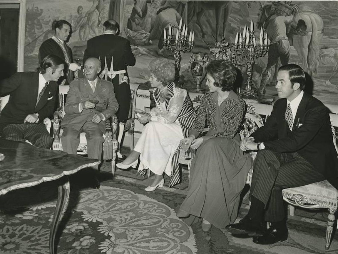 Anuncio del compromiso entre Don Alfonso de Borbón y María del Carmen Bordiú Franco. En la imagen, el Jefe del Estado conversa con su yerno, el marqués de Villaverde, en presencia de la Reina Federica de Grecia y los Reyes Constantino y Ana María de Grecia. 