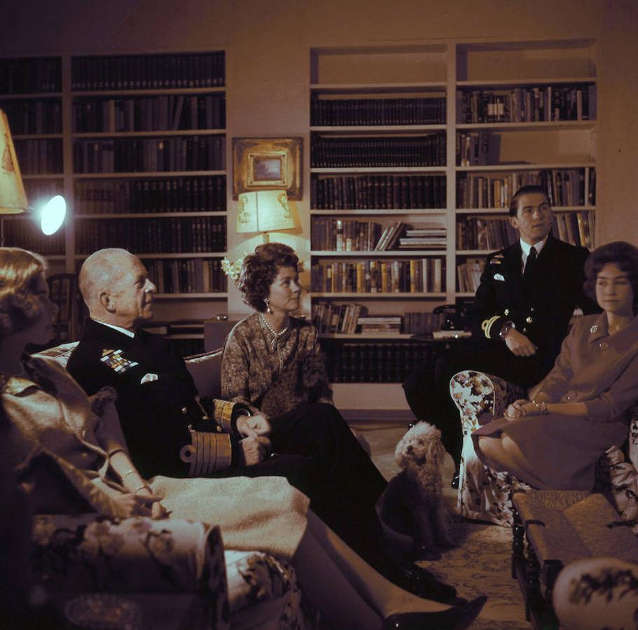 En la fotografía, la Familia Real griega reunida en el gran salón de la residencia de Tatoi. A la izquierda, Su alteza Real la Princesa Irene, seguida del Rey Pablo y la Reina Federica. A la derecha, Sus Altezas Reales la princesa Sofía y el Príncipe Constantino, heredero del trono. 