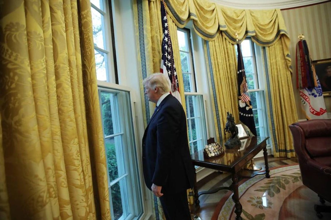 El presidente de los Estados Unidos, Donald Trump, mira por una ventana del Despacho Oval tras una entrevista con Reuters en la Casa Blanca en Washington, EE.UU.. 