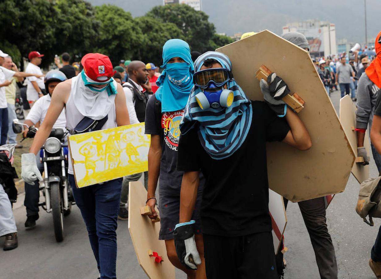 Escudos de madera. La oposición venezolana se enfrenta a los cañones de agua con escudos de madera