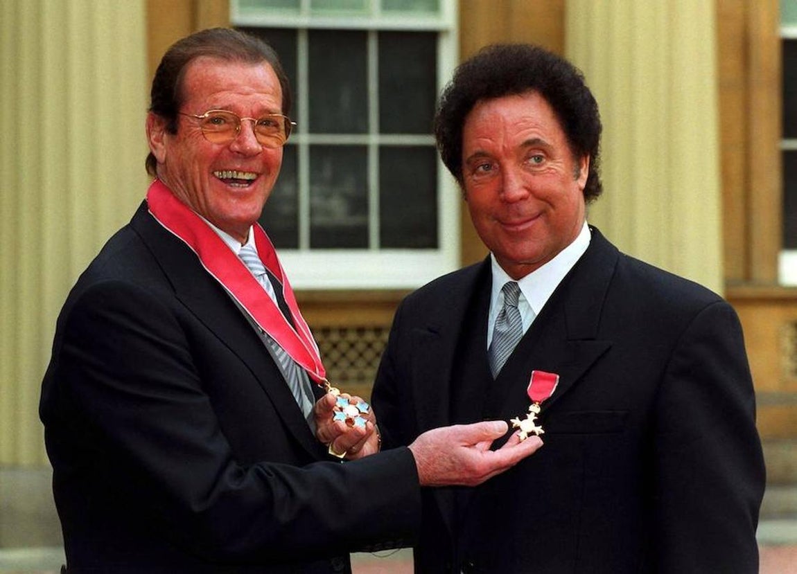 Sir Roger Moore. El actor inglés recibe un homenaje como Comandante de la Orden del Imperio Británico el 9 de marzo de 1999 de manos de la reina Elizabeth II. En el acto también se galardonó al cantante Tom Jones con la orden.