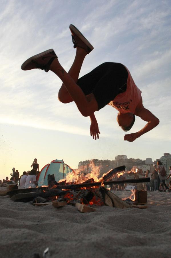 Un joven salta una hoguera en una playa de La Coruña, durante la noche de San Juan  