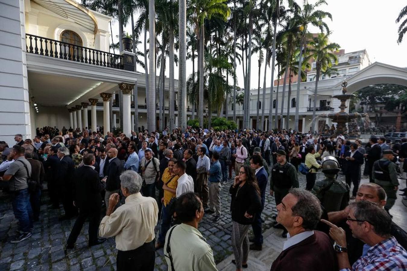Diputados, periodistas y asistentes a los actos conmemorativos del día de la Independencia de Venezuela permanecen en las afueras del Palacio Legislativo de la Asamblea Nacional de Venezuela.