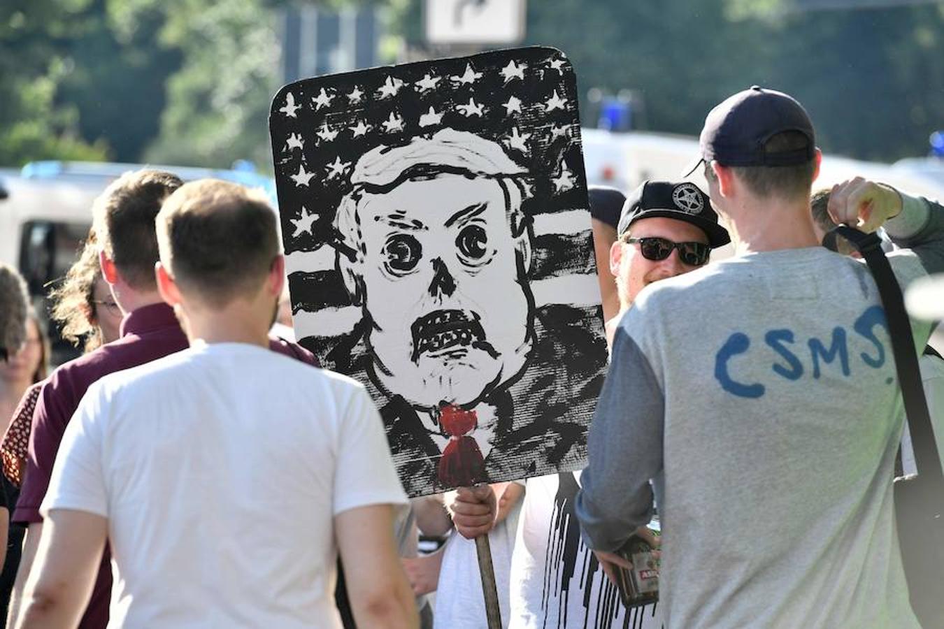 Protestas contra Trump. Unos manifestantes muestran una pancarta con el dibujo de Donal Trump durante el «Welcome to Hell».