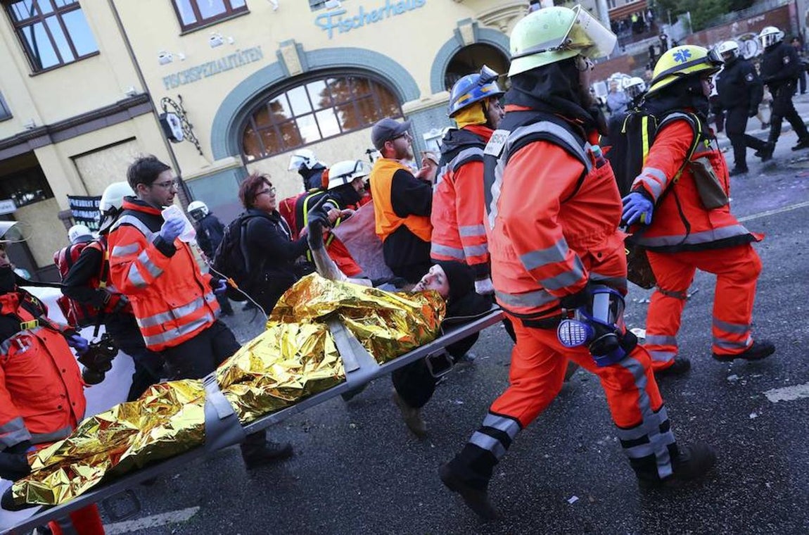 Un manifestante herido hace un corte de mangas mientras es transportado en una camilla.. 