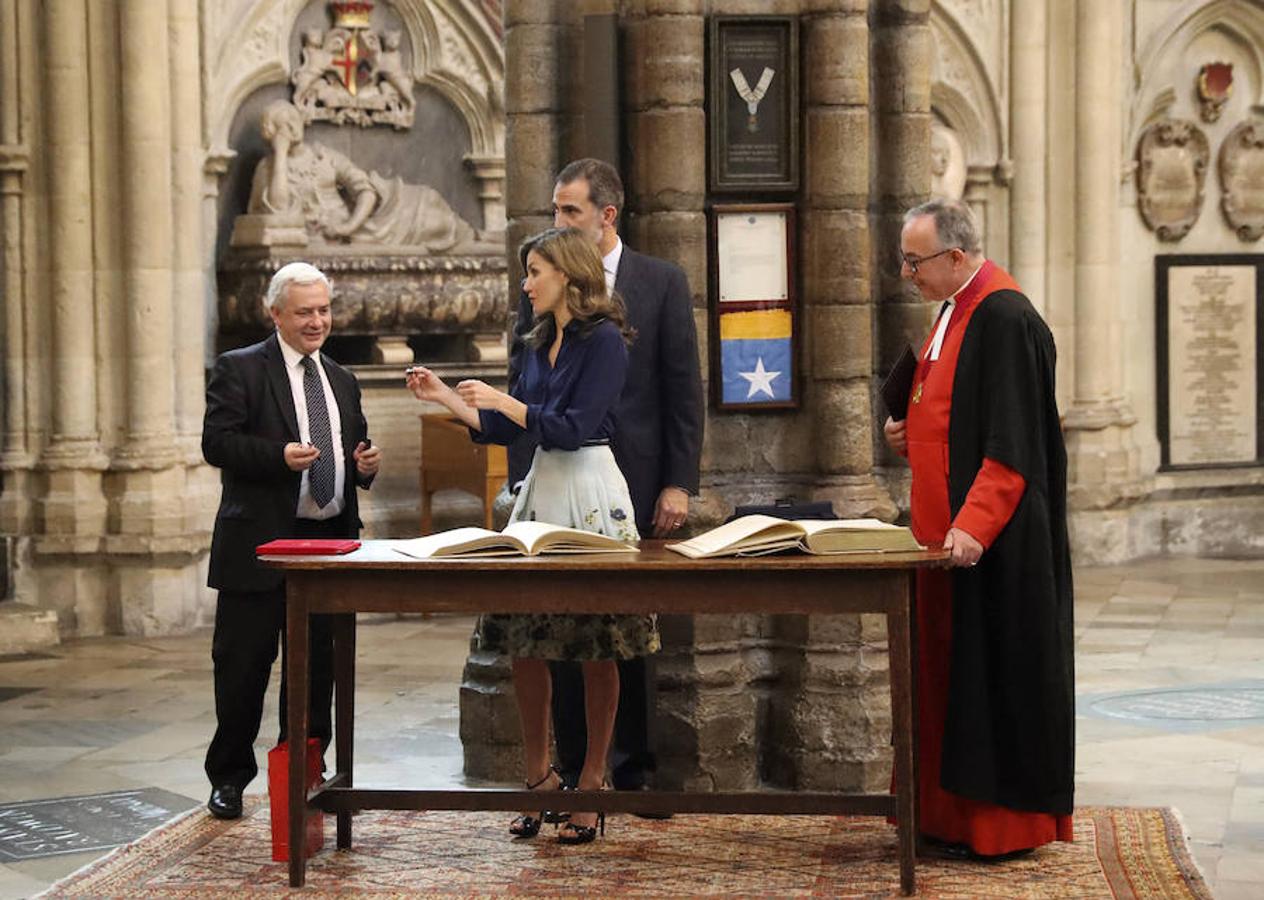 El rey Felipe y la reina Letizia firman el Libro de Honor durante la visita realizada hoy a la abadía de Westminster. Efe