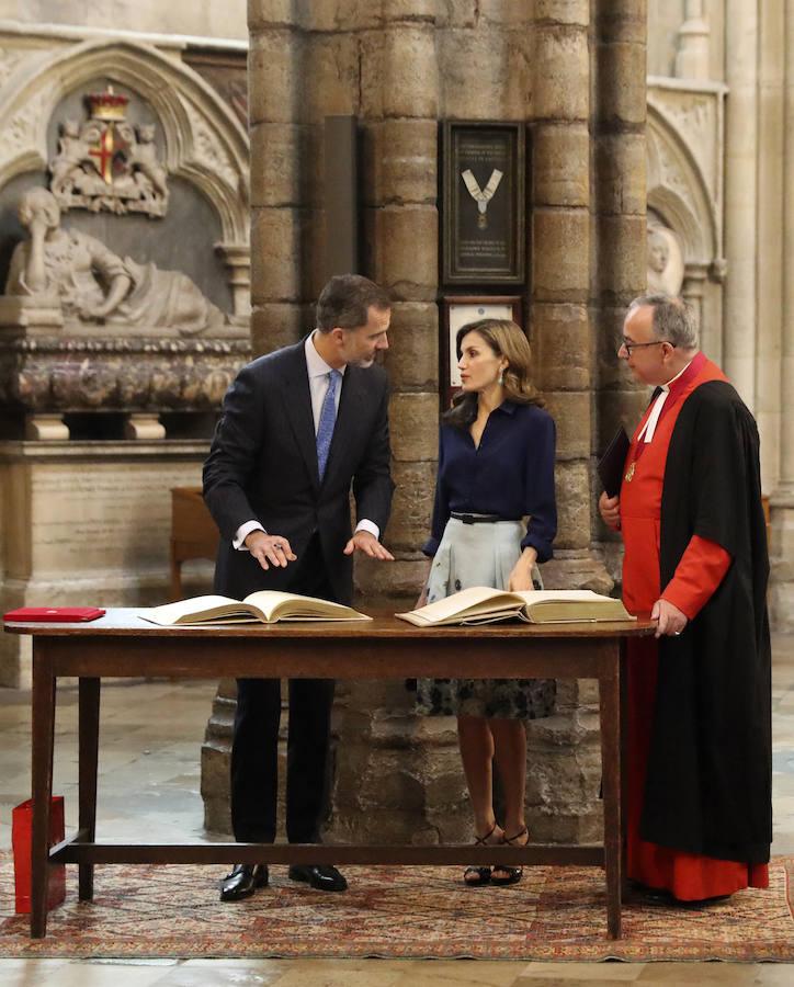 El rey Felipe y la reina Letizia firman el Libro de Honor durante la visita realizada hoy a la abadía de Westminster. Efe