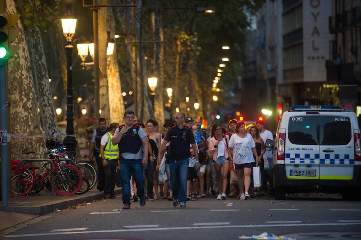 Agentes de paisano evacúan de la zona acordonada a las personas que buscaron refugio en tiendas o comercios. 