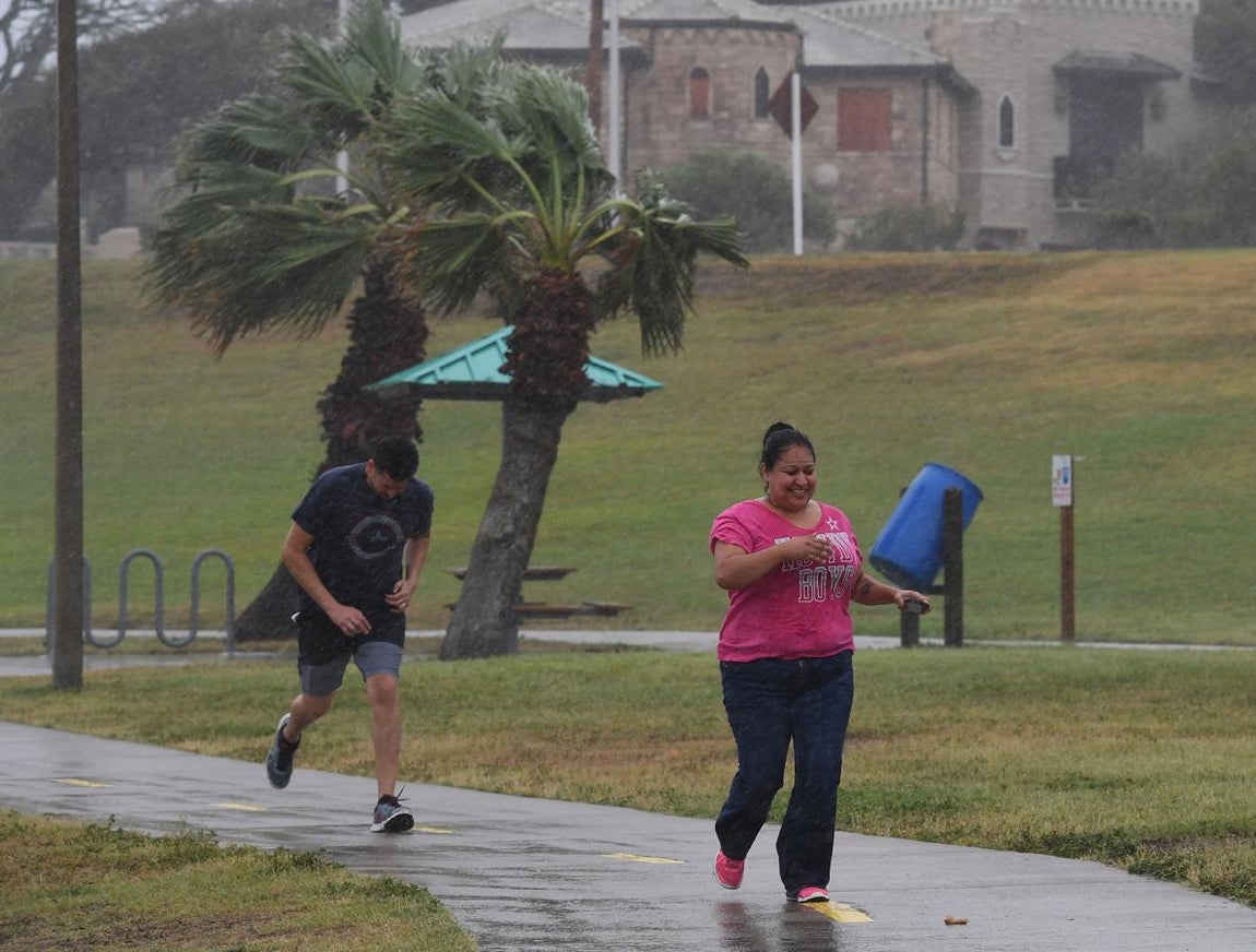 Huracán Harvey. Dos hombres corren en la ciudad de Corpus Christi ante el intenso vendaval