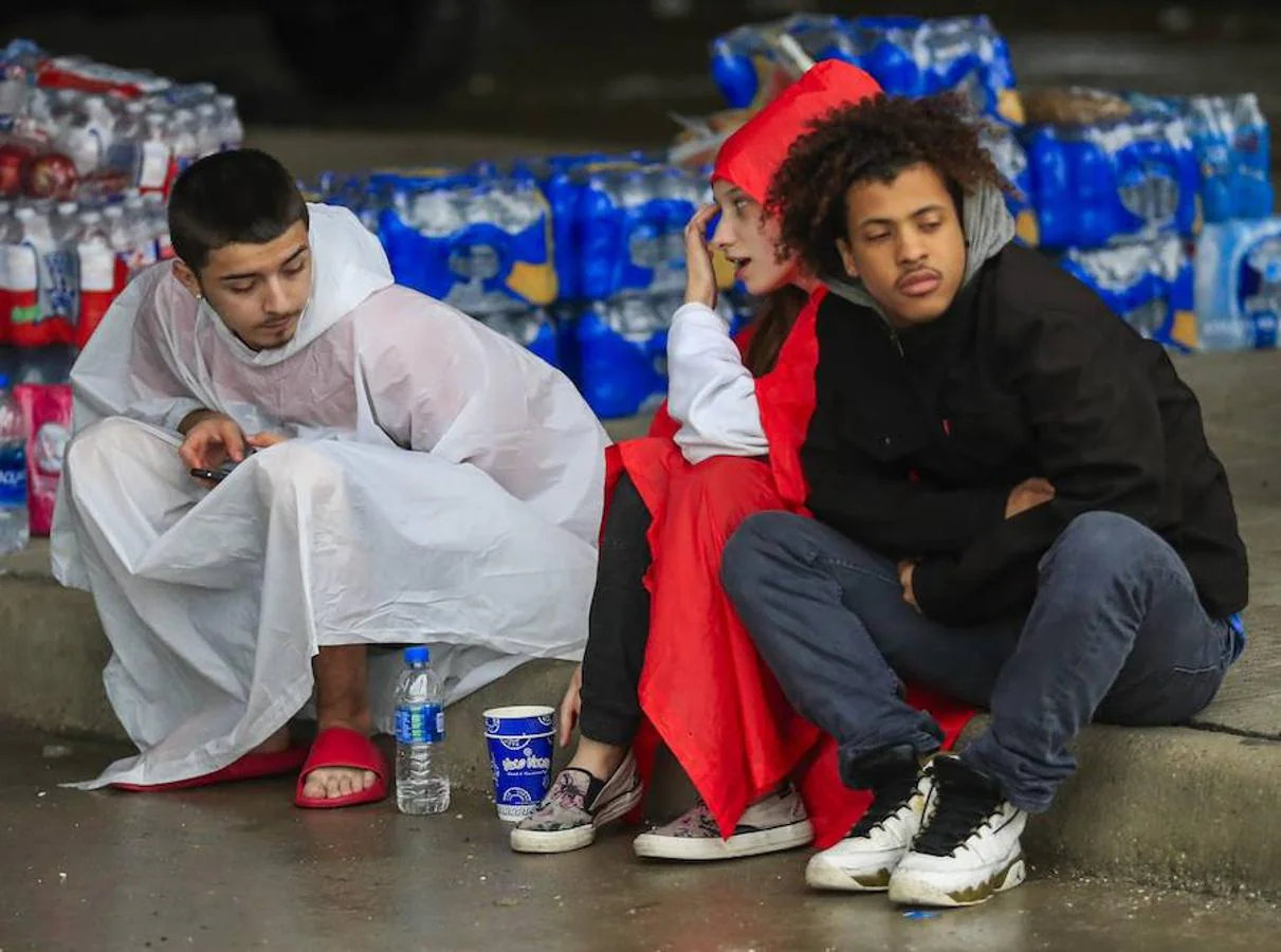 Un grupo de jóvenes conversa junto a paquetes de ayudas y alimentos para los afectados por las inundaciones después del huracán. 
