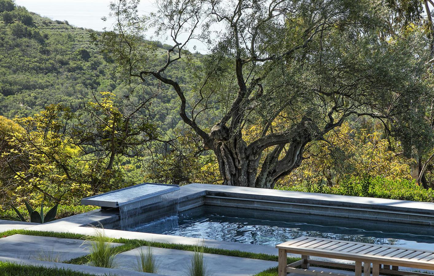 Serena. Una piscina con cascada bajo un árbol situada en plena montaña. Desde su interior se escuchan el sonido del agua y el canto de los pájaros. También se contempla el infinito donde el verde de la vegetación se confunde con el azul del agua y el cielo. Todo un Spa en el jardín