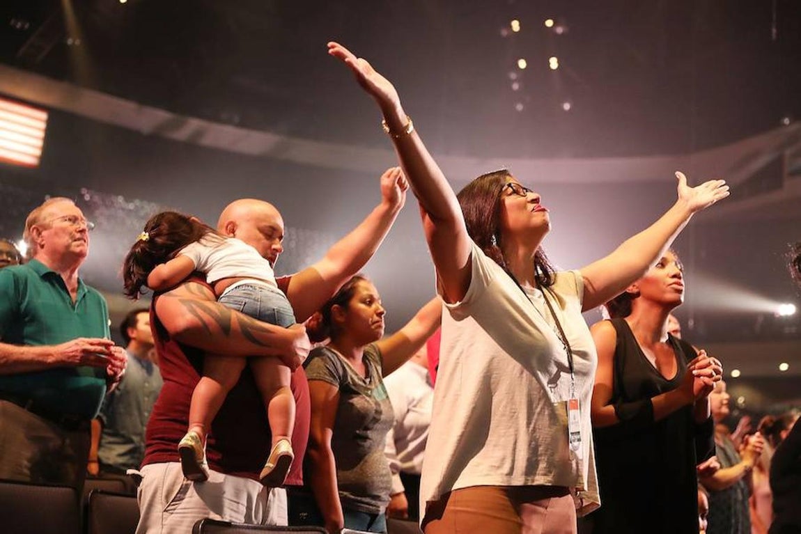 Rezos. Feligreses de la Iglesia Lakewood rezan juntos irigidos por el pastor Joel Osteen