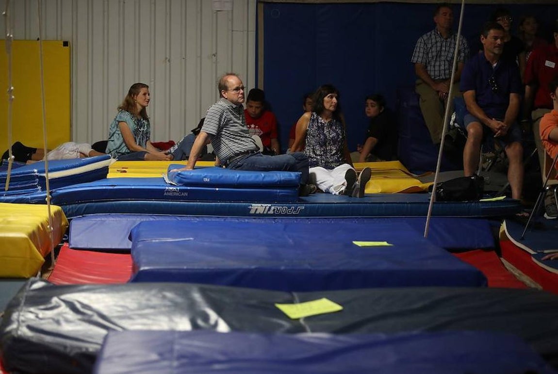 Alojamiento. Miembros de la comunidad cristiana de Cypress Creek sentados en las colchonetas del gimansio Base's Gymnastics