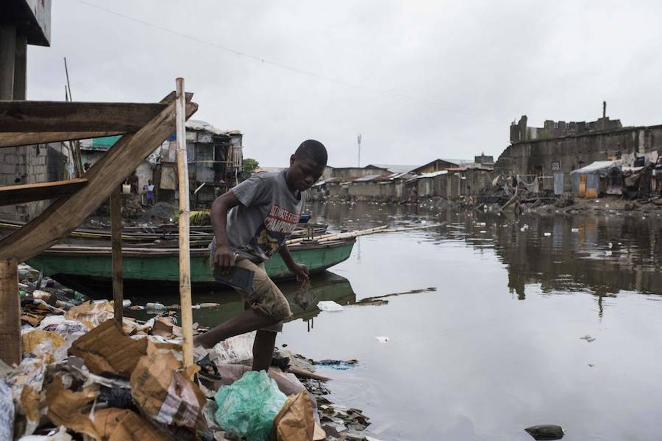 Un joven busca pedazos de un espejo roto en Haití. 