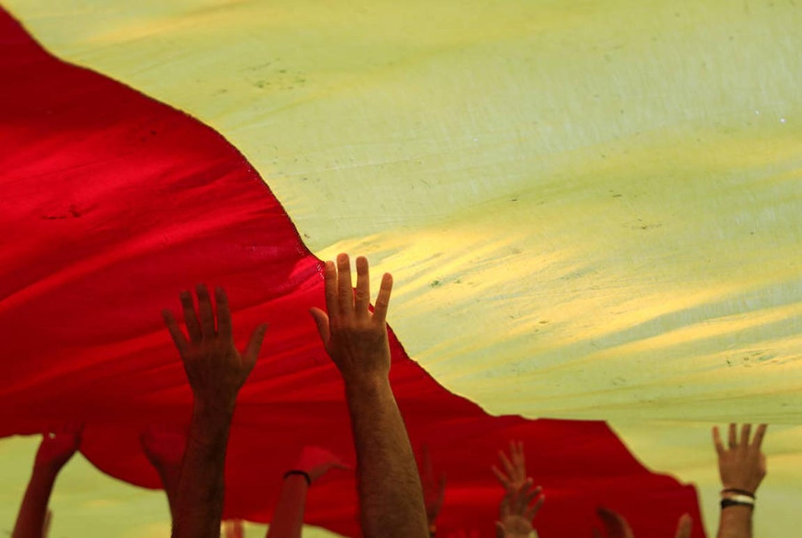 Manos de los asistentes cargando la «estelada» gigante. 
