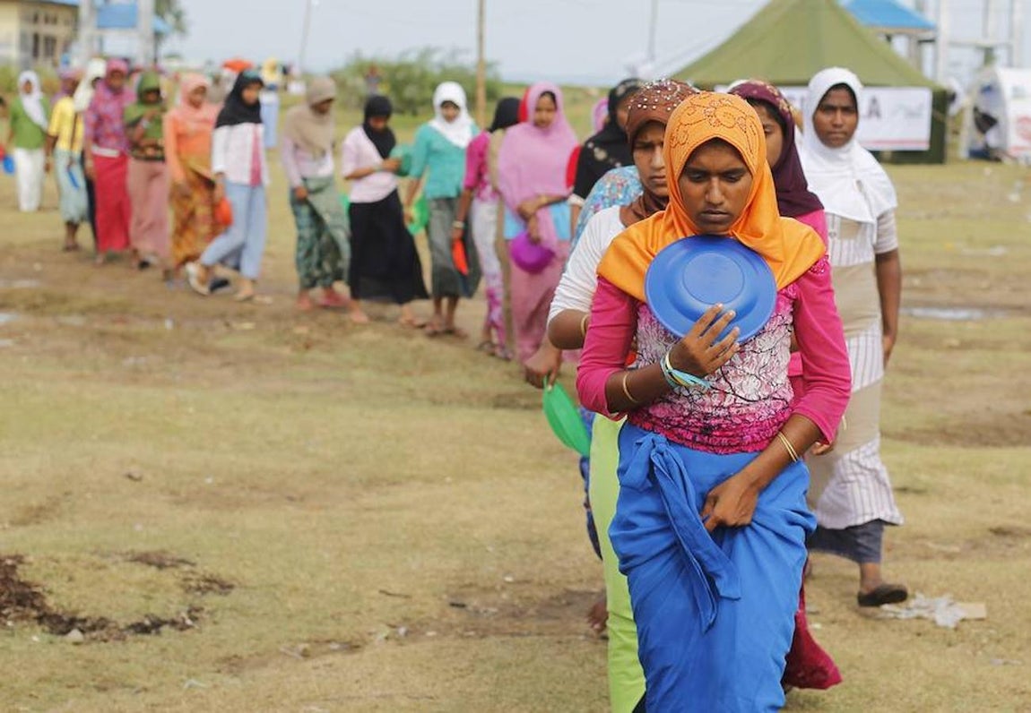 Mujeres rohingyas hacen cola para recibir su desayuno en un campo de refugiados de Indoanesia.. 