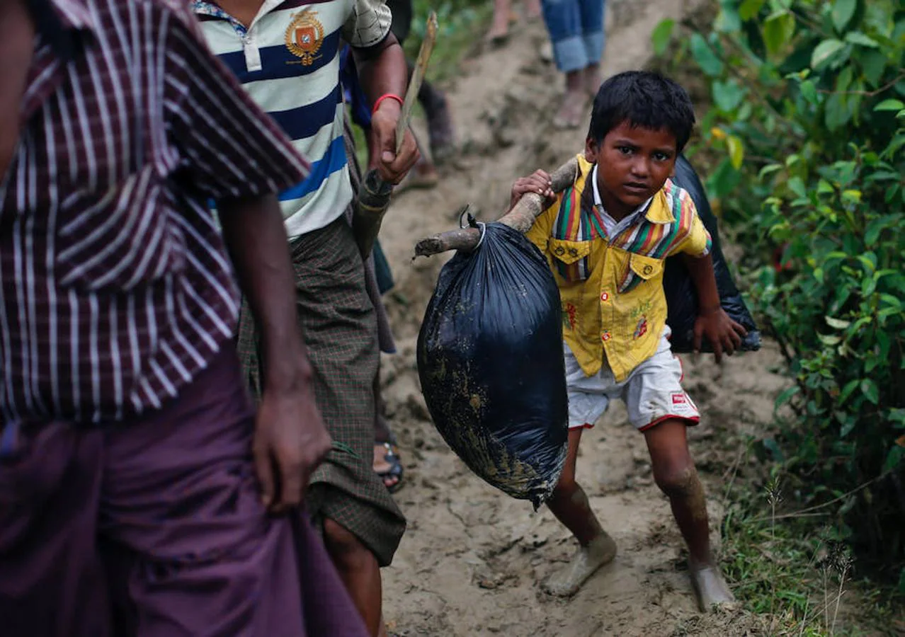 Un niño rohingya carga con sus pertenencias en un campo de refuagiados de Cox's Bazar, en Bangladesh.. 