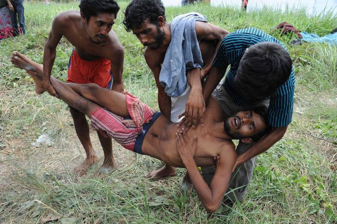 Varios inmigrantes rohingyas transportan a un hombre enfermo a su llegada al pueblo costero de Kuala Langsa, en Indonesia.. 