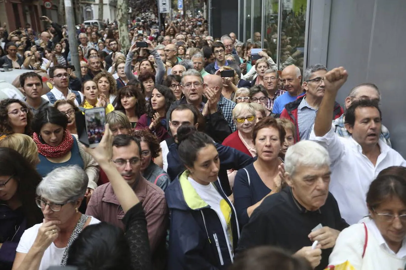 Decenas de personas haciendo cola frente al colegio Ramón Llull de Barcelona. 