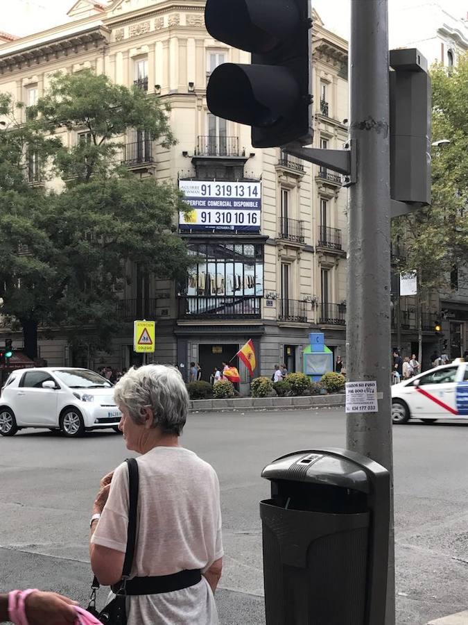 Dos jóvenes portan la bandera española por el centro de Madrid. 