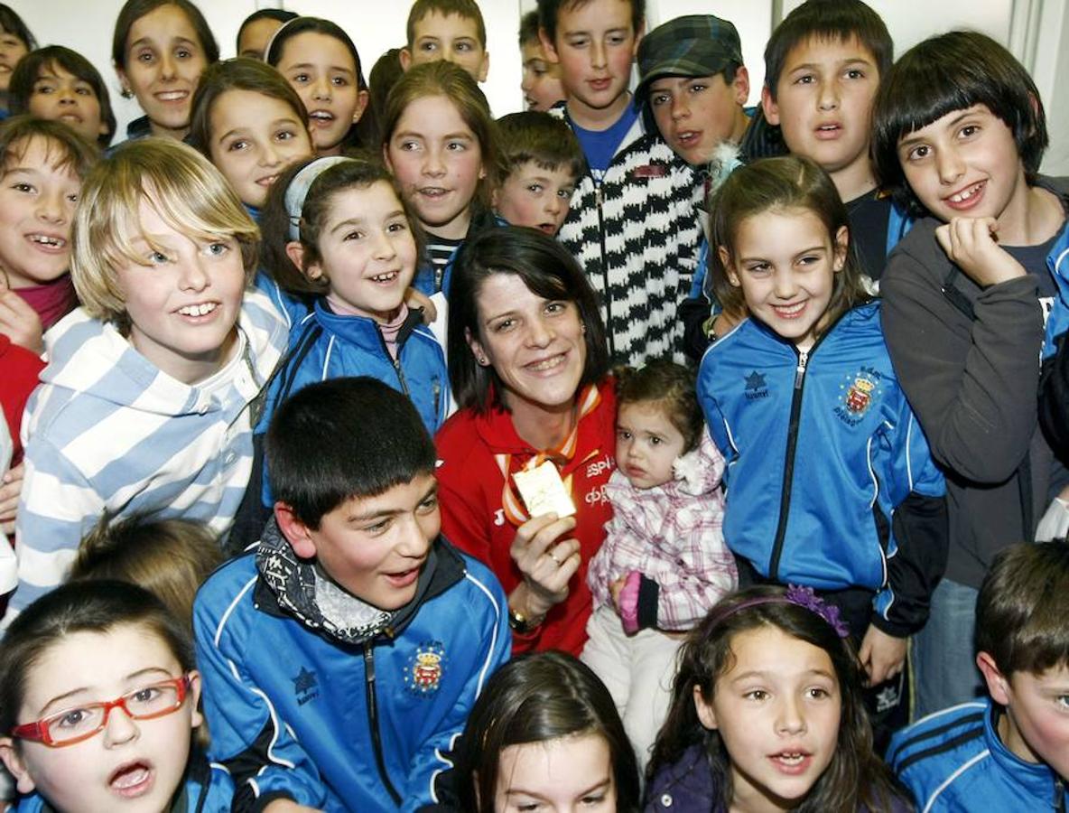 Rodeada por varios niños de su club de atletismo, el Pielagos Intelecma, a su llegada al aeropuerto de Santander (marzo 2010). 