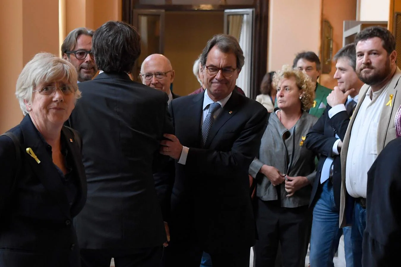 Artur Mas felicita a Puigdemont en los pasillos del Parlament. 