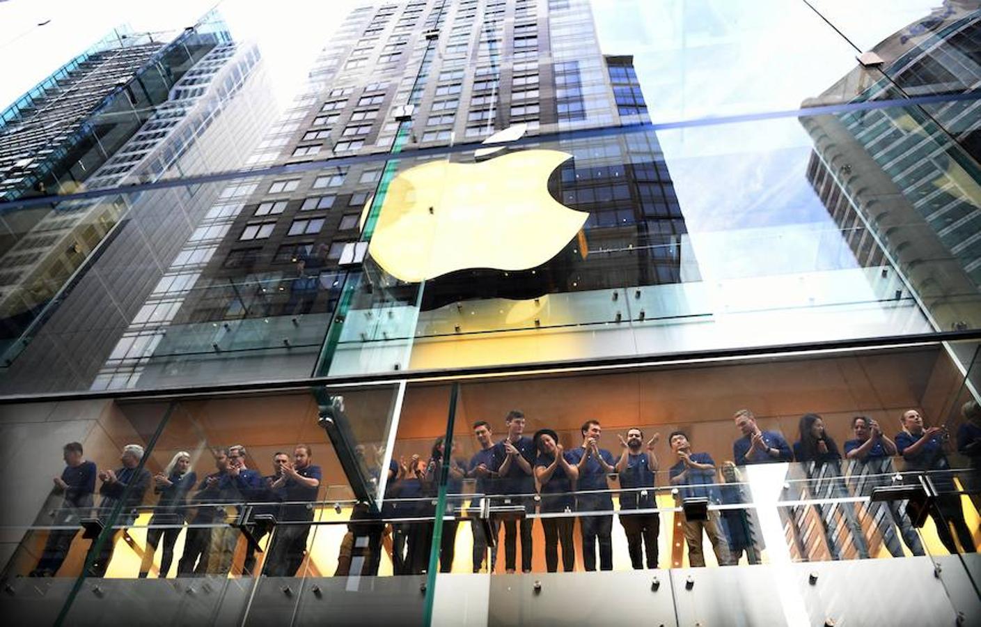 El personal de una tienda Apple observa a varias personas que hacen cola en una tienda Apple en Sídney, Australia. 