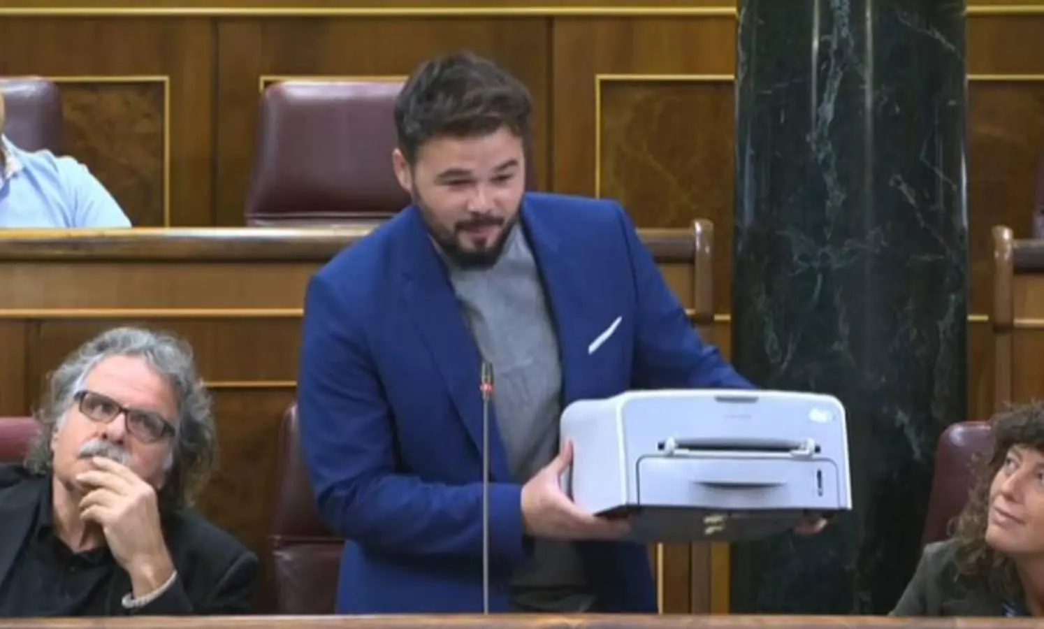 Rufián muestra una impresora desde su estrado: «Es una humilde Samsung republicana, no es muy peligrosa». Fue su manera de defender el referéndum en Cataluña en el Congreso de los Diputados, a un mes de que se celebrara.. 