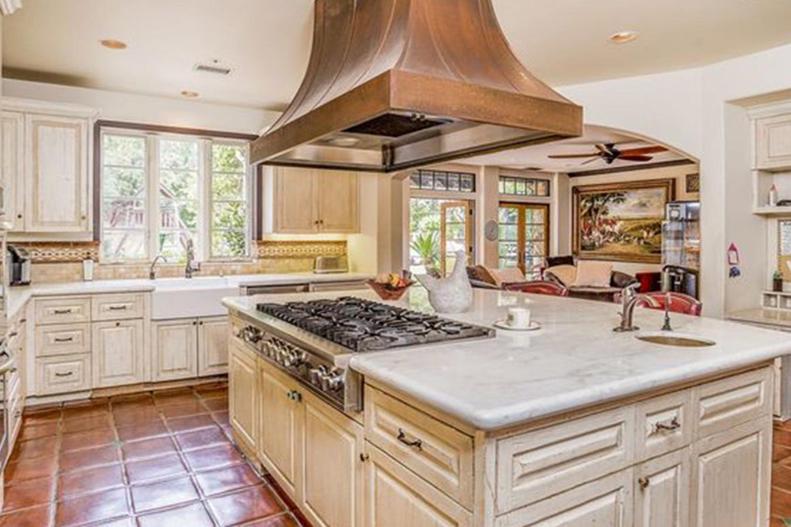 Cocina estilo colonial. La cocina es muy luminosa y comunica con una de las zonas arboladas más bellas del jardín. La vegetación de esta parte de la casa inspira nostalgia, un detalle que los decoradores han sabido aprovechar dotando a la estancia con muebles blancos de estilo colonial que consiguen dar un sentido completo a la habitación