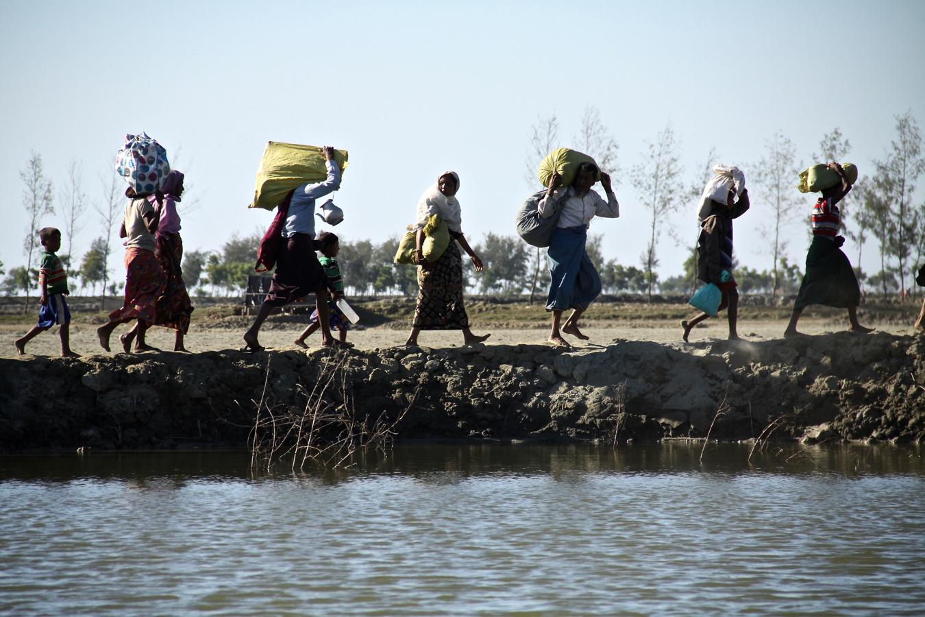 Tras cruzar el río Naf desde Birmania hasta la isla de Shapuree, los refugiados rohingyas avanzan sus últimos metros hacia el punto de entrada de Sabrang, donde el Ejército de Bangladés los registra. 