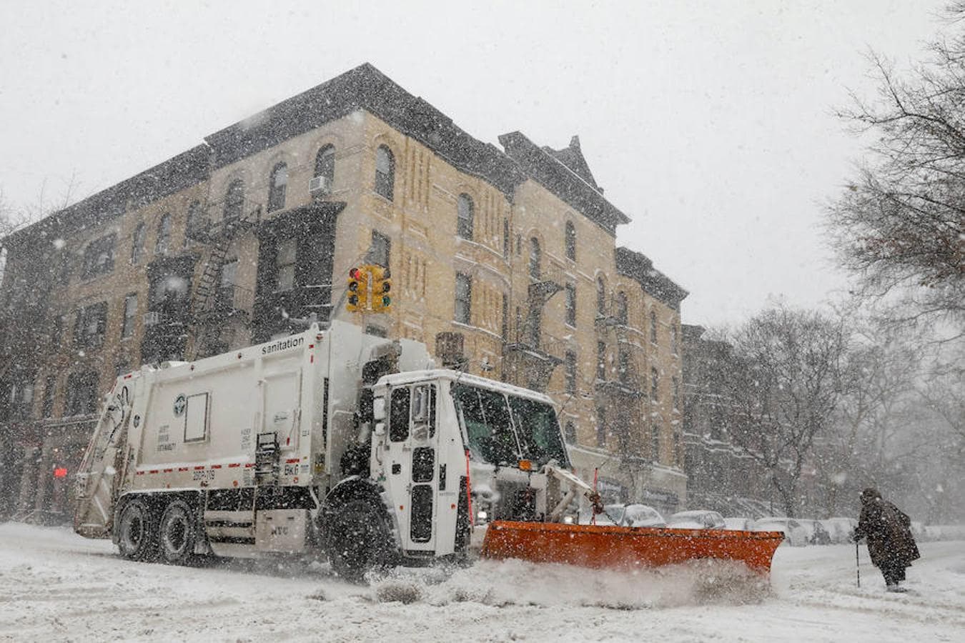 Un camión de la basura se abre paso entre la nieve en el neoyorquino barrio de Brooklyn.. 
