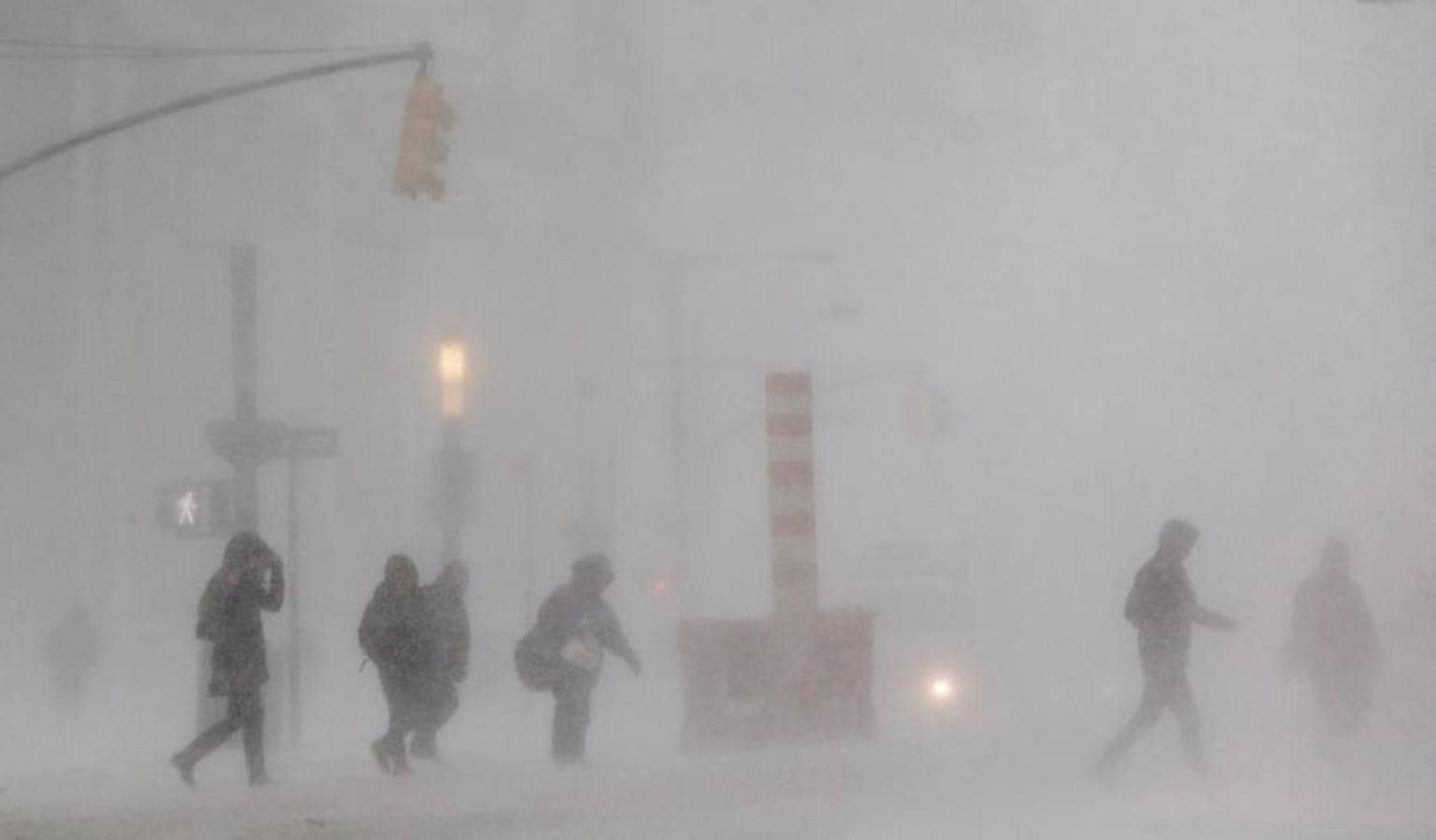 Peatones cruzan la calle Broadway durante la tormenta de viento y nieve de Nueva York.. 