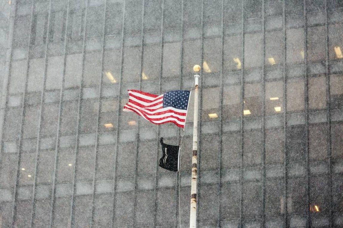 La bandera de los Estados Unidos ondea durante la tormenta de nieve que estos días asola Nueva York.. 