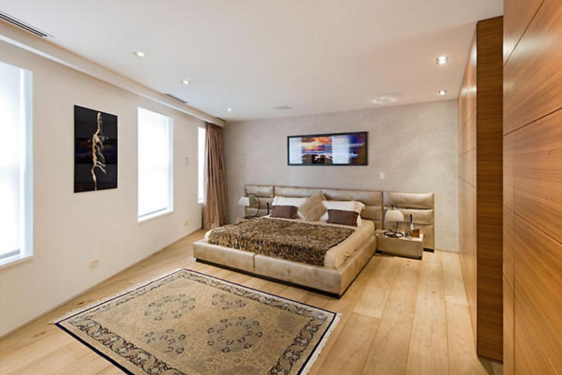 Dormitorio de invitados. La segunda planta comunica directamente con la habitación de invitados por una escalera de aluminio. Un lujo para las visitas, con suelos de madera, cuarto de baño privado, grandes ventanales e intimidad