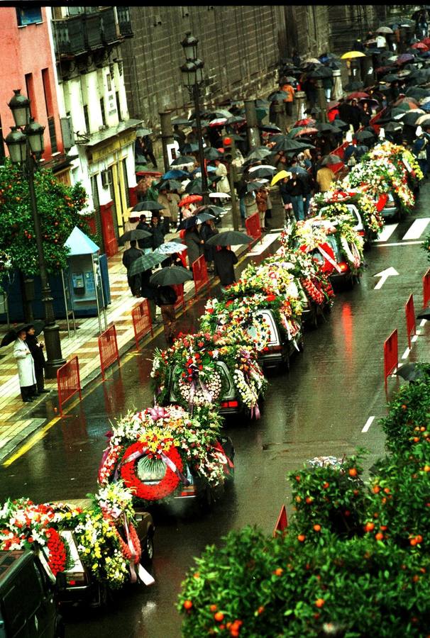 Coches fúnebres con coronas de flores en la avenida de la Constitución