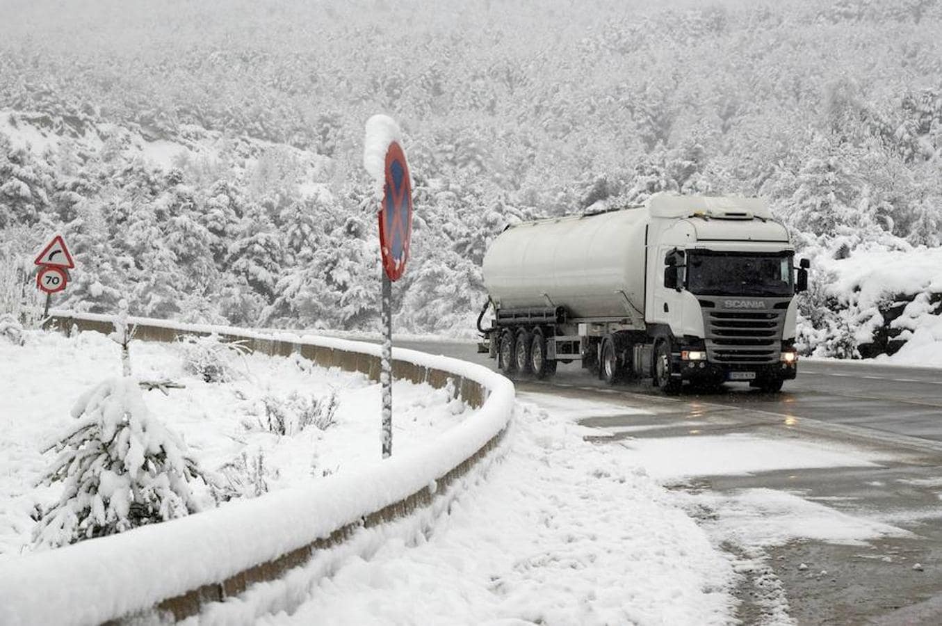 Un camión circula esta tarde por la N-330 cubierta de nieve a la altura del puerto de Monrepós (Huesca).. 