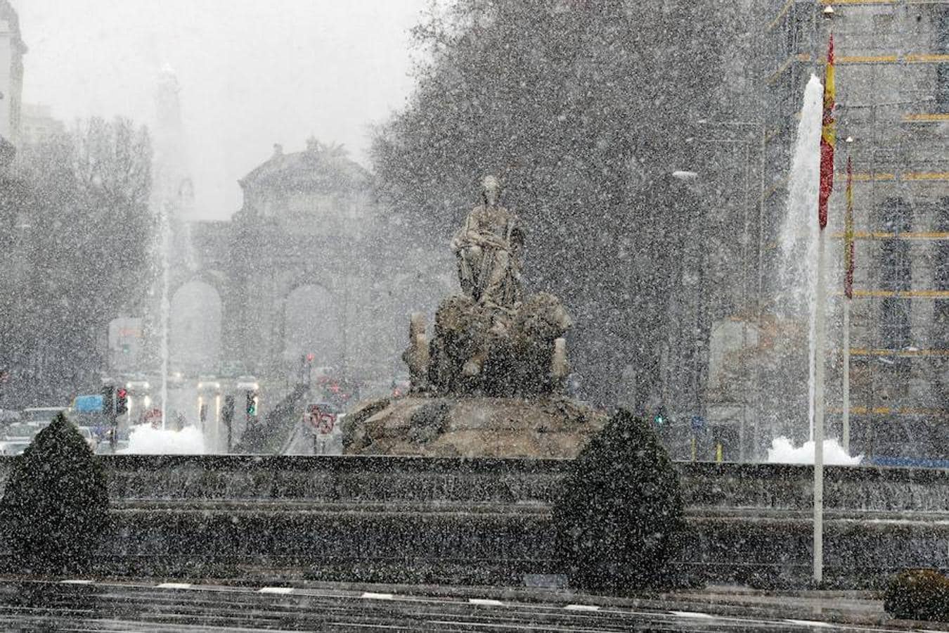 La fuente de la Cibeles, en Madrid, oculta tras los gruesos copos de nieve que han caído hoy sobre la capital. 