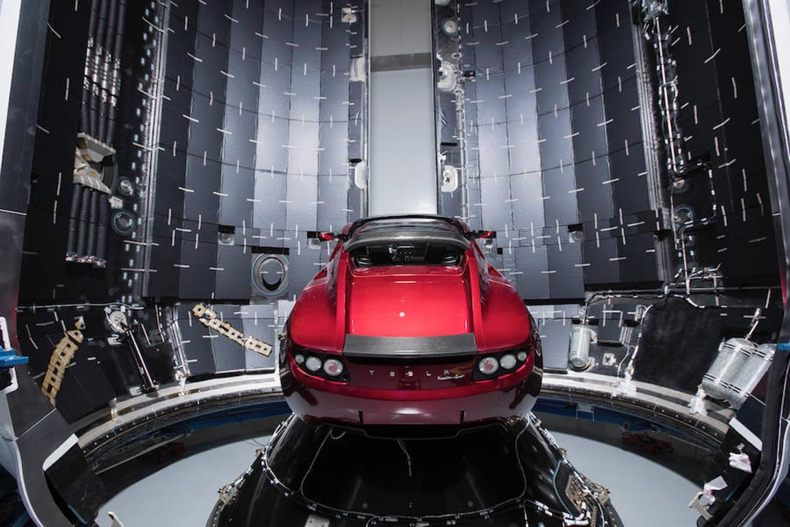 Fotografía cedida por SpaceX, donde aparece el automóvil eléctrico Tesla de color rojo, montado dentro del cohete Falcon Heavy que lo dejará en una órbita cercana a Marte si la misión se desarrolla como está previsto. 