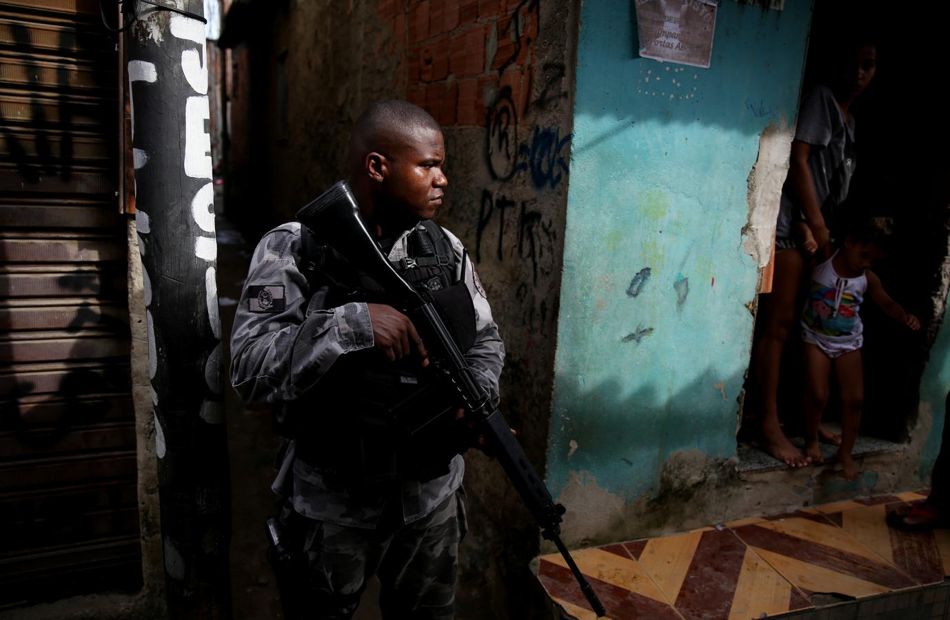 Un militar hace guardia junto a una casa de la favela de Kelson. 