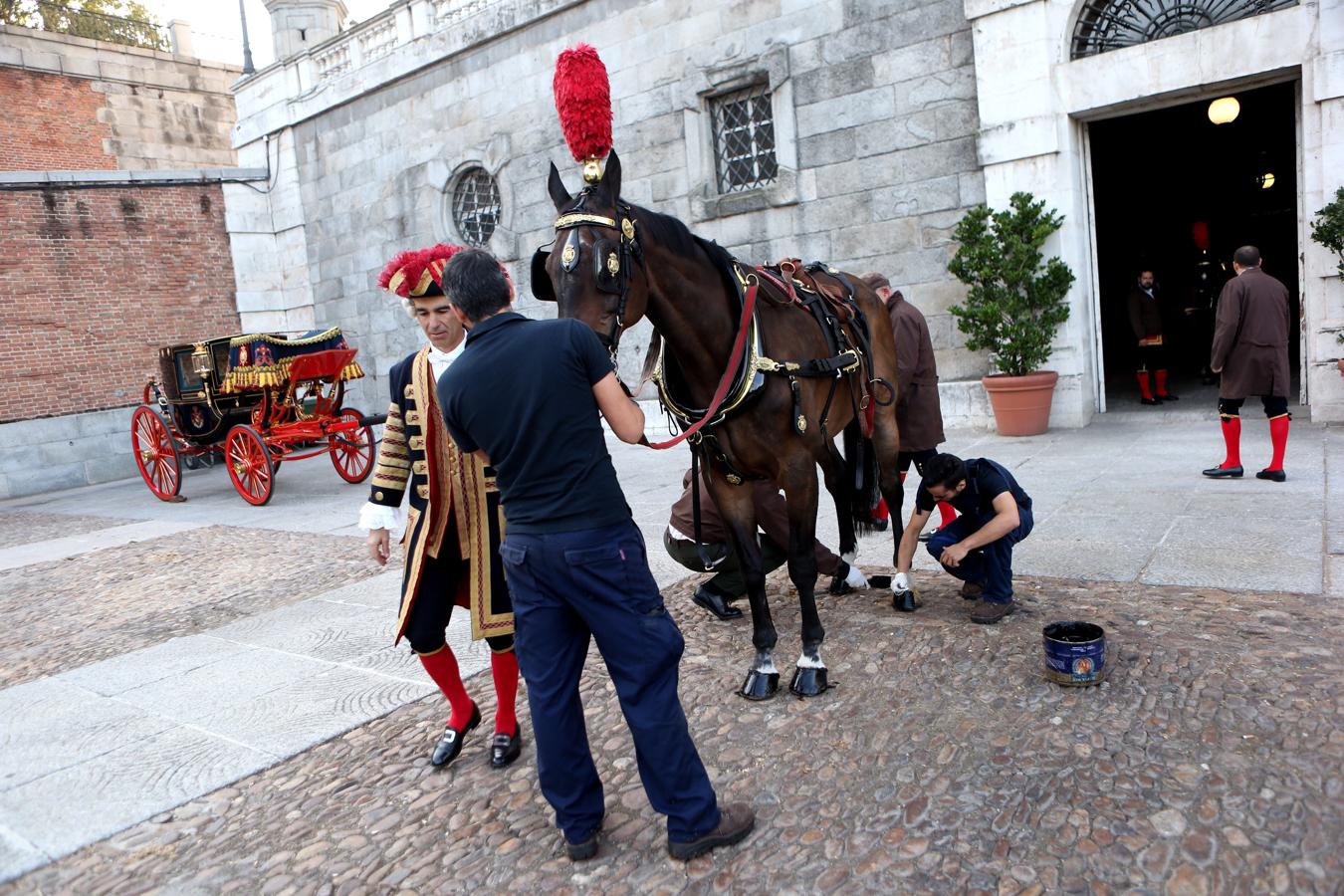 El momento de la «pedicura». Ya fuera de las cuadras, con una brocha se pintan los cascos de los caballos con grasa negra, lo que además de embellecerles les protege