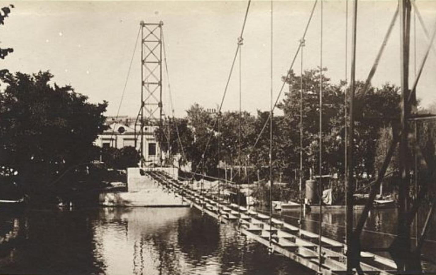Pasarela colgante en construcción hacia 1925. Junto a la orilla, barca con la draga. Foto de José Vera. Archivo Municipal de Toledo. 