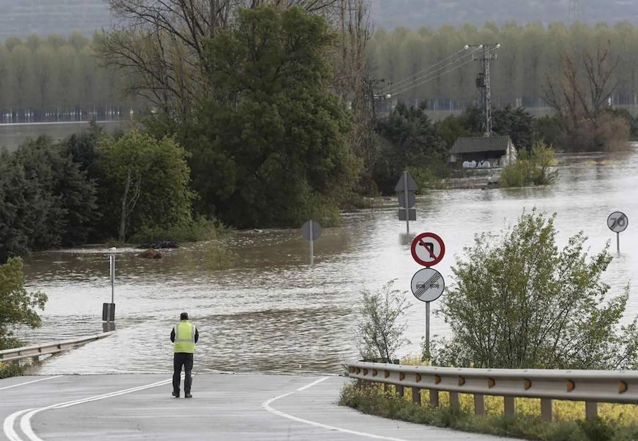 Una persona toma imágenes de la carretera N-113 que permanece cortada hacia Castejón tras el desbordamiento del Rio Ebro.. 