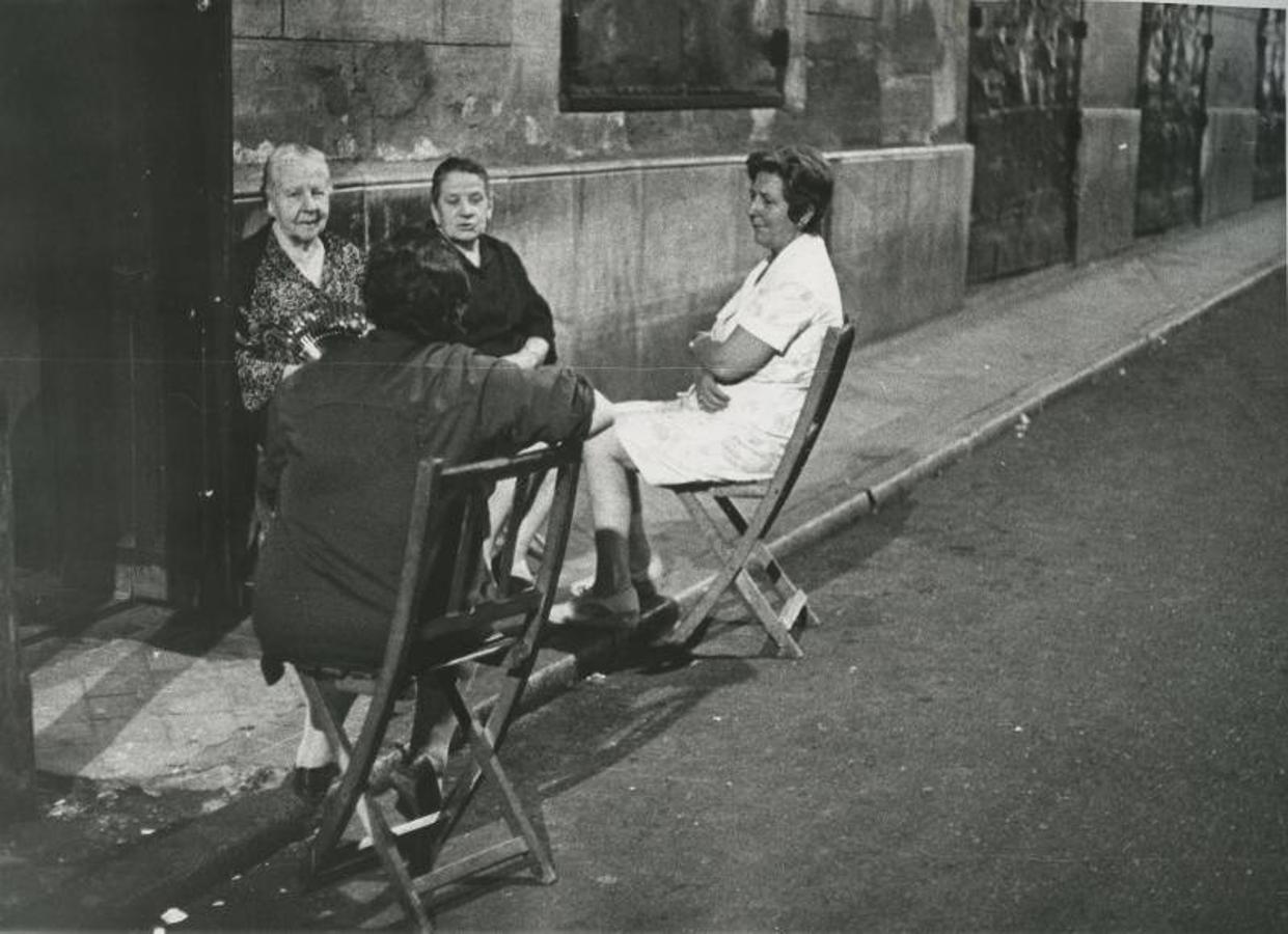 En agosto de 1972, cuatro mujeres pasan la noche sentadas en las puertas de sus casas, al aire libre, para evitar el calor. 