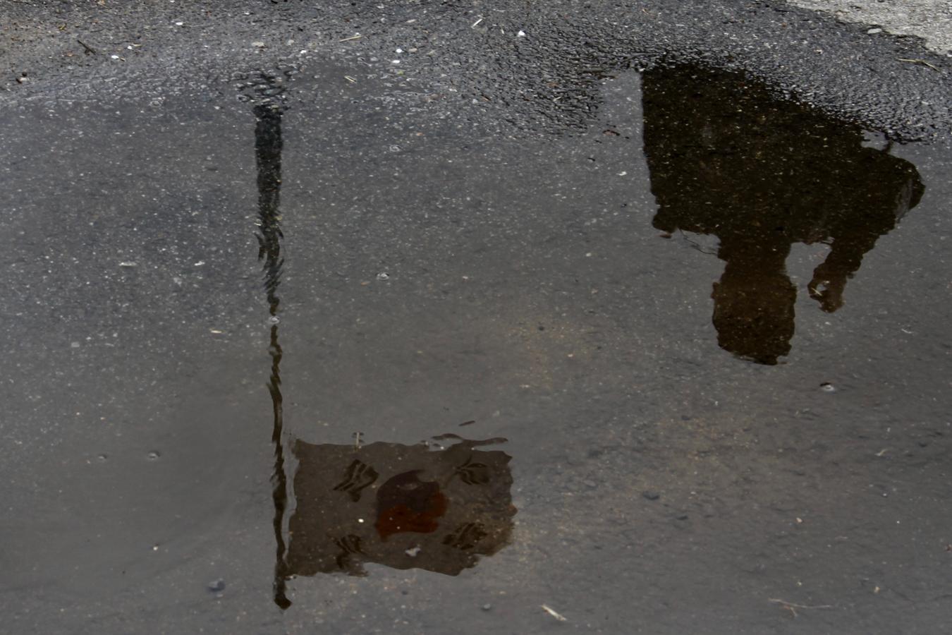 La bandera surcoreana de Taesung, que mide unos cien metros, se refleja sobre un charco junto a uno de los soldados que vigilan el pueblo. 