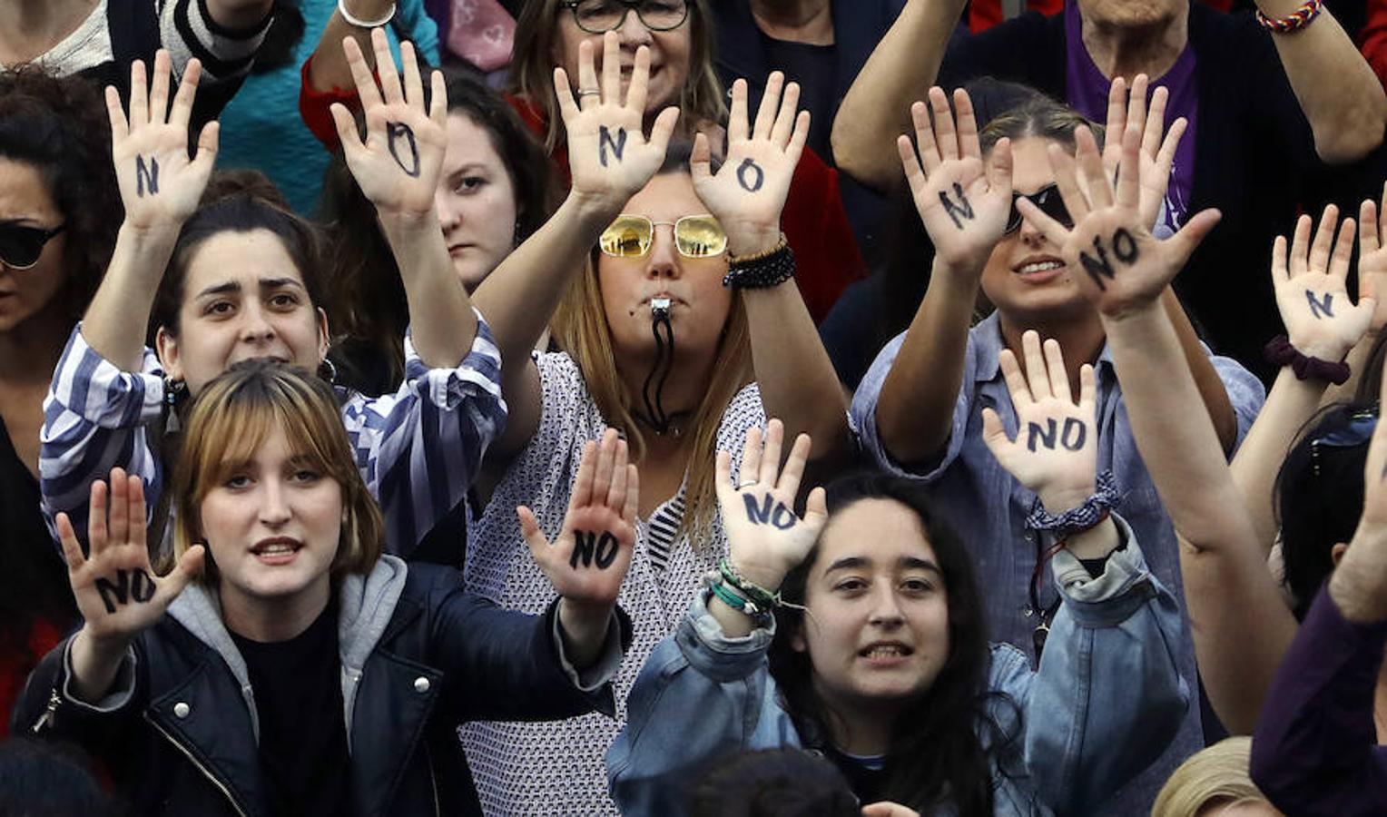 Varias jóvenes muestran sus manos rotuladas con un «No» durante la manifestación ante el Ayuntamiento de Valencia.. 