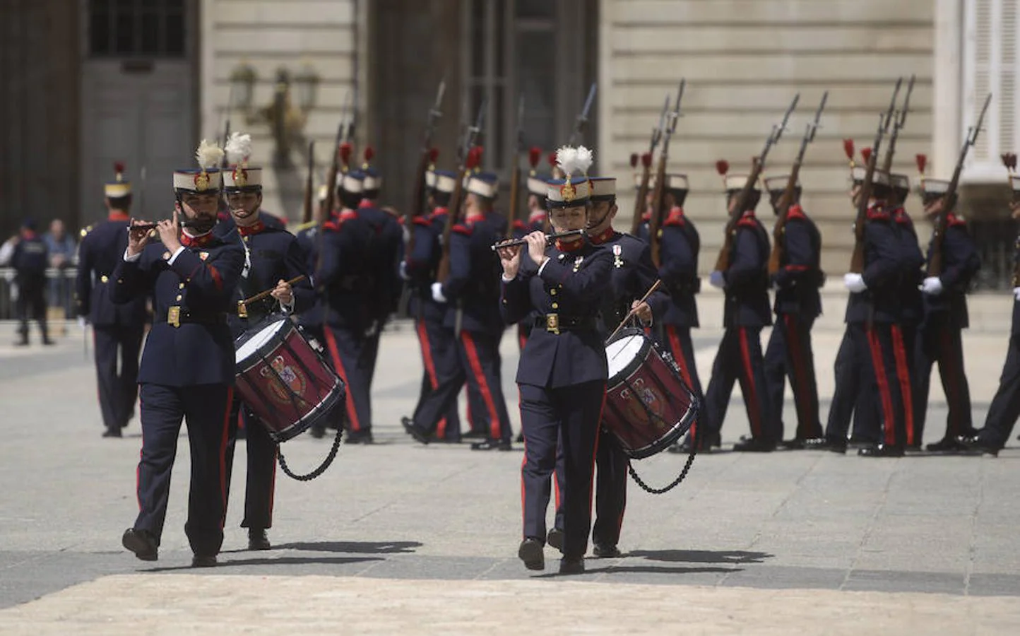 1. Cuerpo mixto. Los alabarderos, hombres y mujeres, desfilan, en este caso tocando diferentes instrumentos musicales, por la explanada frente al Palacio Real.